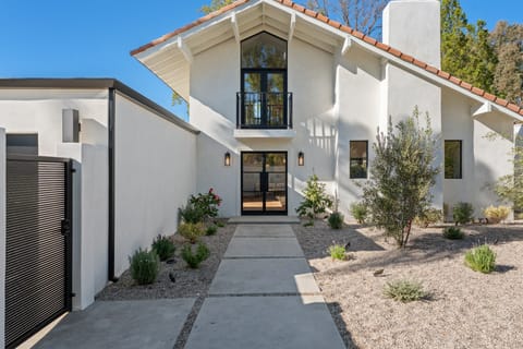 The same home's gabled entry, with black-framed doors and drought-tolerant landscaping